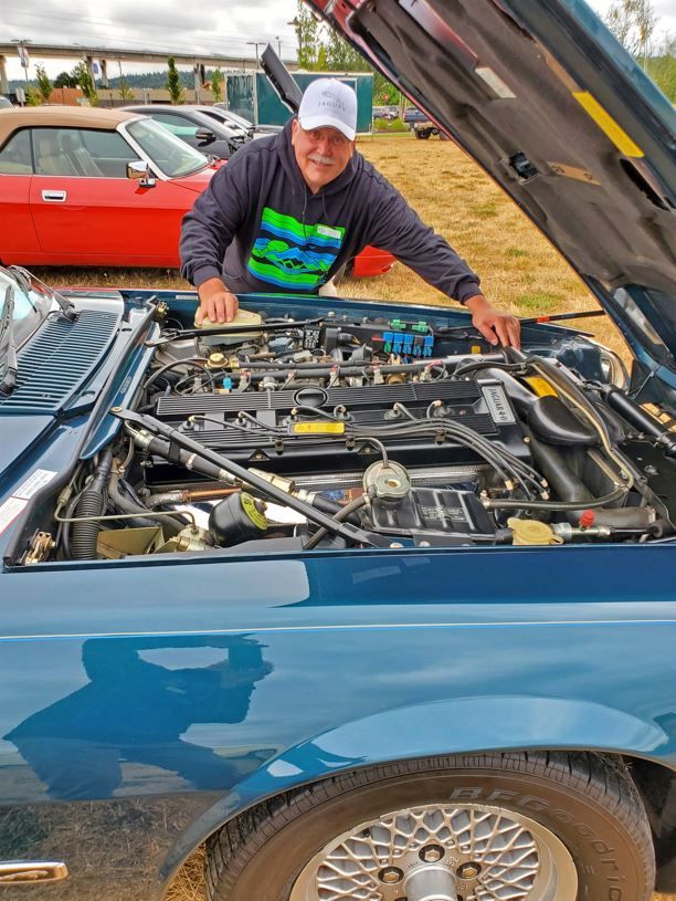 Chuck, checking on his engine compartment, made it to the cover of the Concours Bonus JagMag.