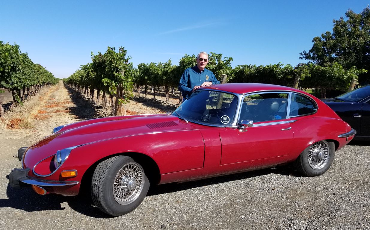 Brian and his E-Type in front of the vineyard.